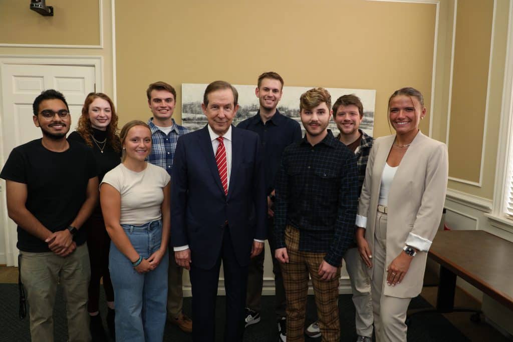 Chris Wallace poses with RMC political science and communications studies majors after a Q&A session