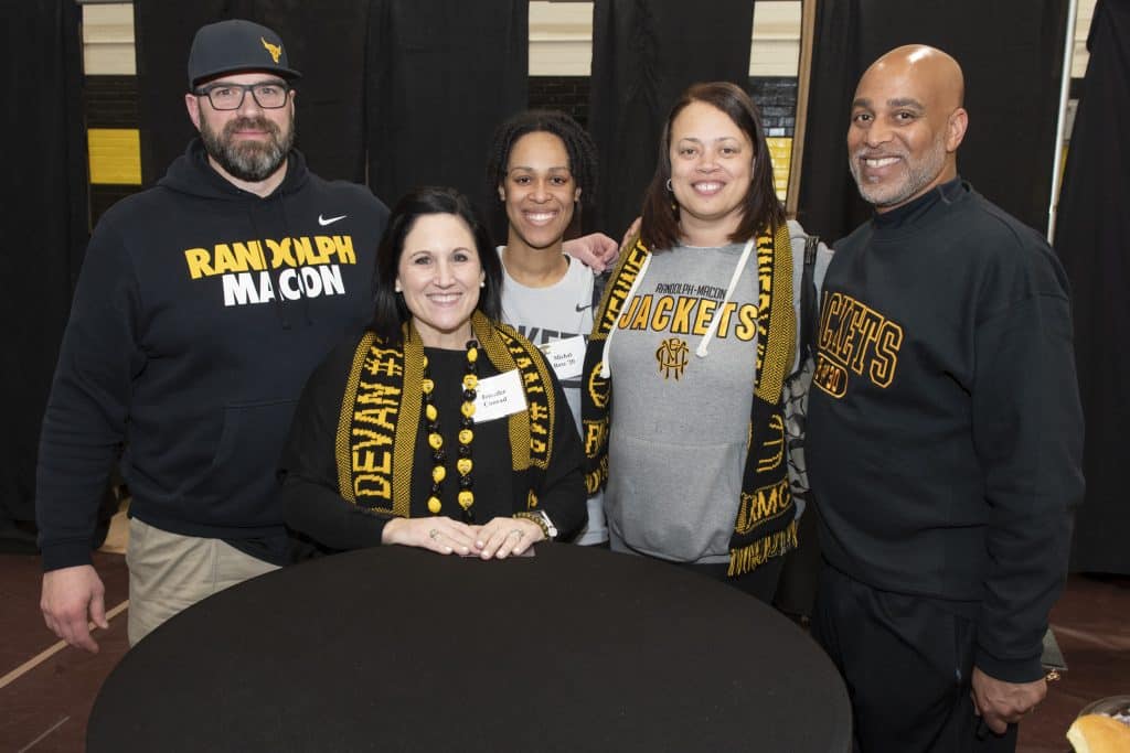 A group of RMC alumni pose for a photo in their lemon and black swag.