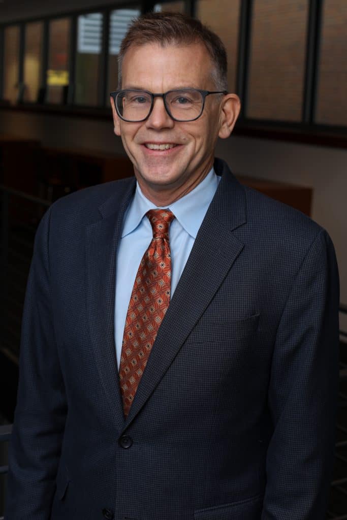 A man in a suit and tie with a professional appearance, suitable for SEO meetings and keyword discussions.