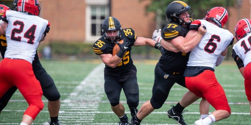 Nick Hale '23 runs through a hole created by his fraternal twin Matt Hale '23 during an RMC football game against Catholic.