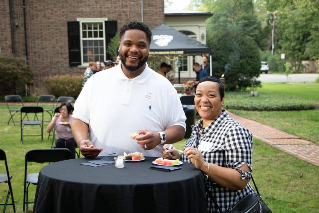 A man and a woman attending an admitted student event, standing at a table.
