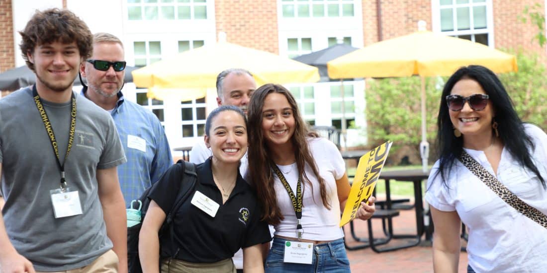 A group of admitted students smiling and walking in a courtyard during an admitted student event.