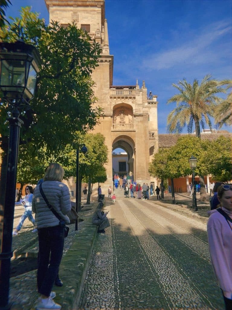 A group of people walking on a path in front of a building.