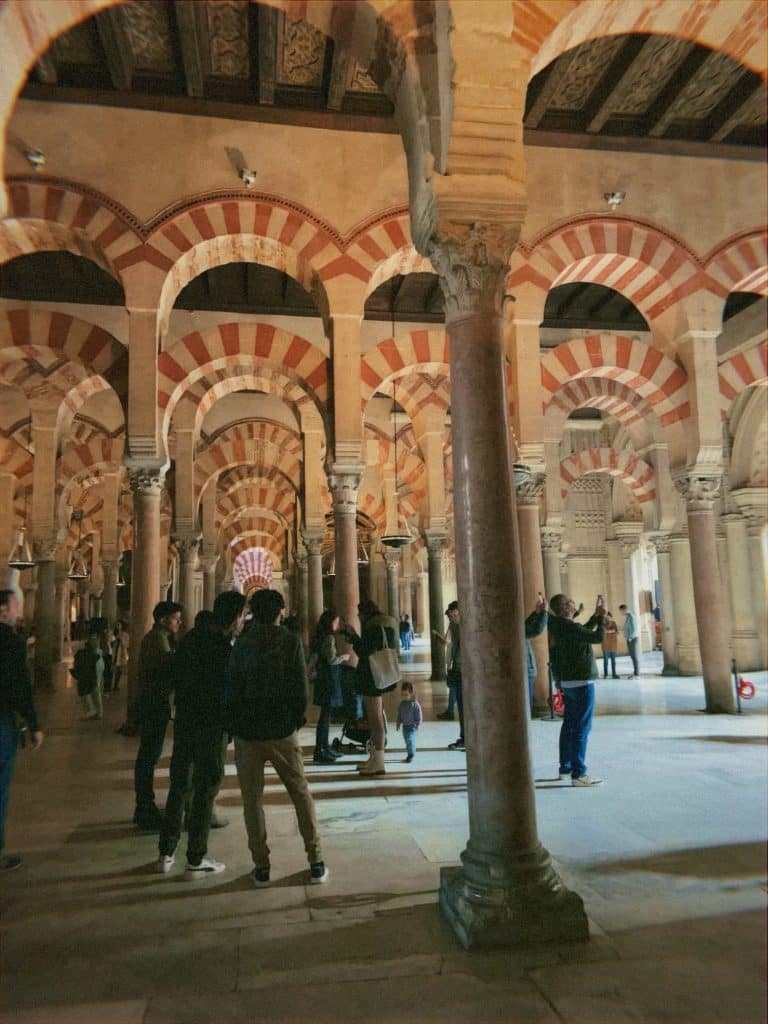 A group of people in a room with columns.