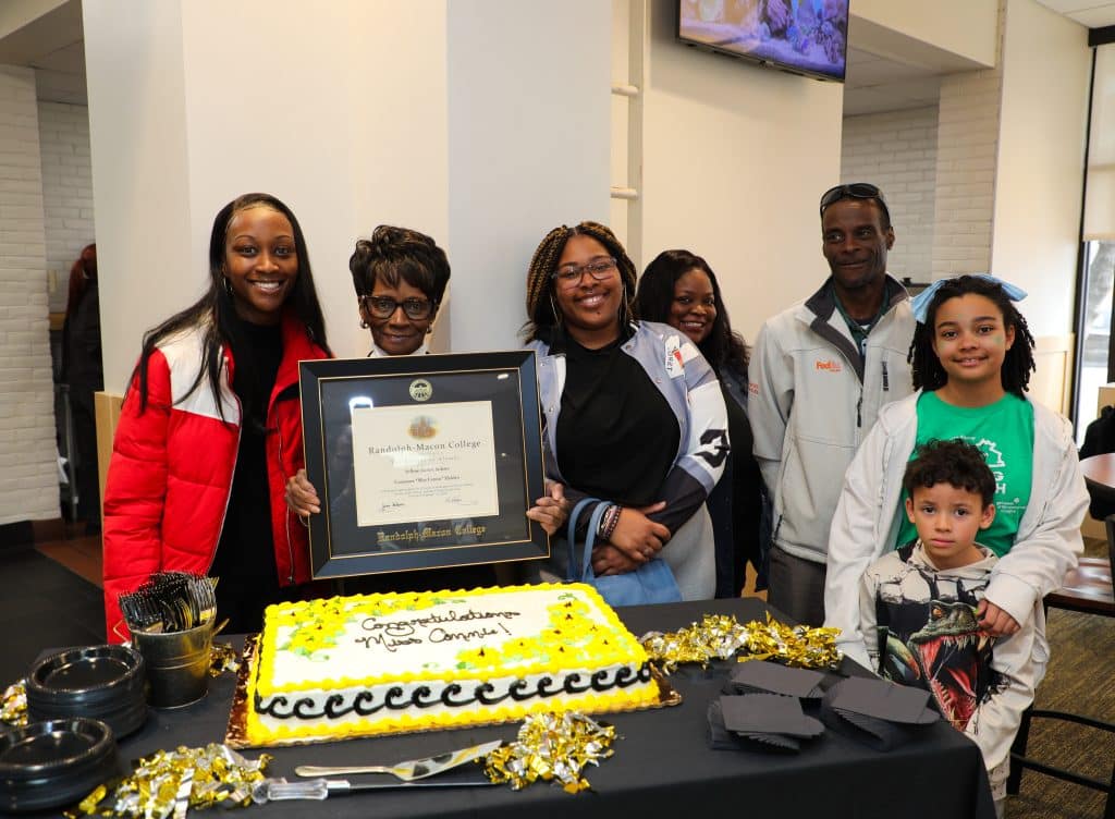 A group of people posing for a picture with a framed certificate.