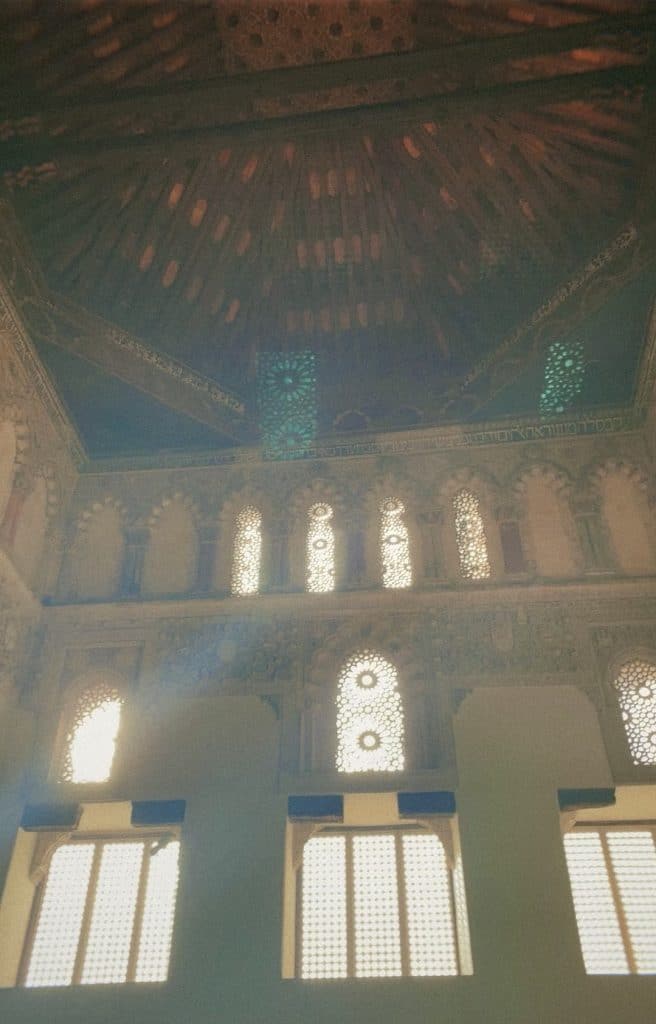 The ceiling of a building with ornate windows.