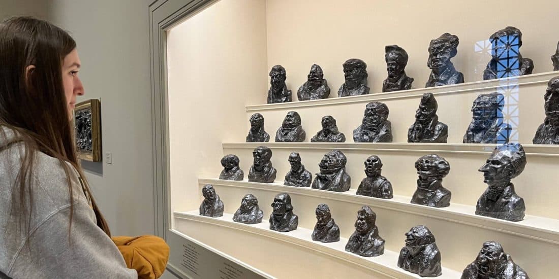 A woman looking at a display of sculptures at the National Gallery of Art.