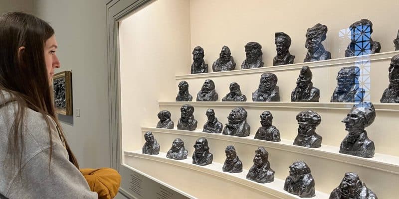 A woman looking at a display of sculptures at the National Gallery of Art.