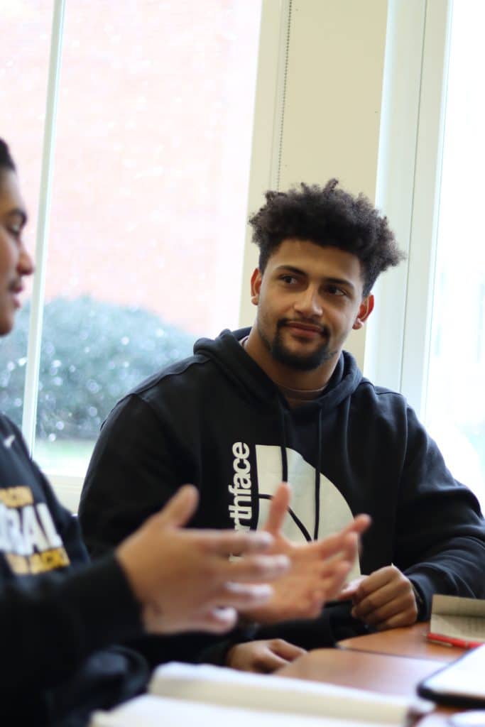 Two male students have a discussion during class