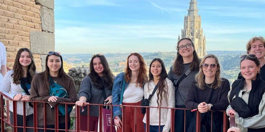 A group of people posing for a photo in front of a castle.