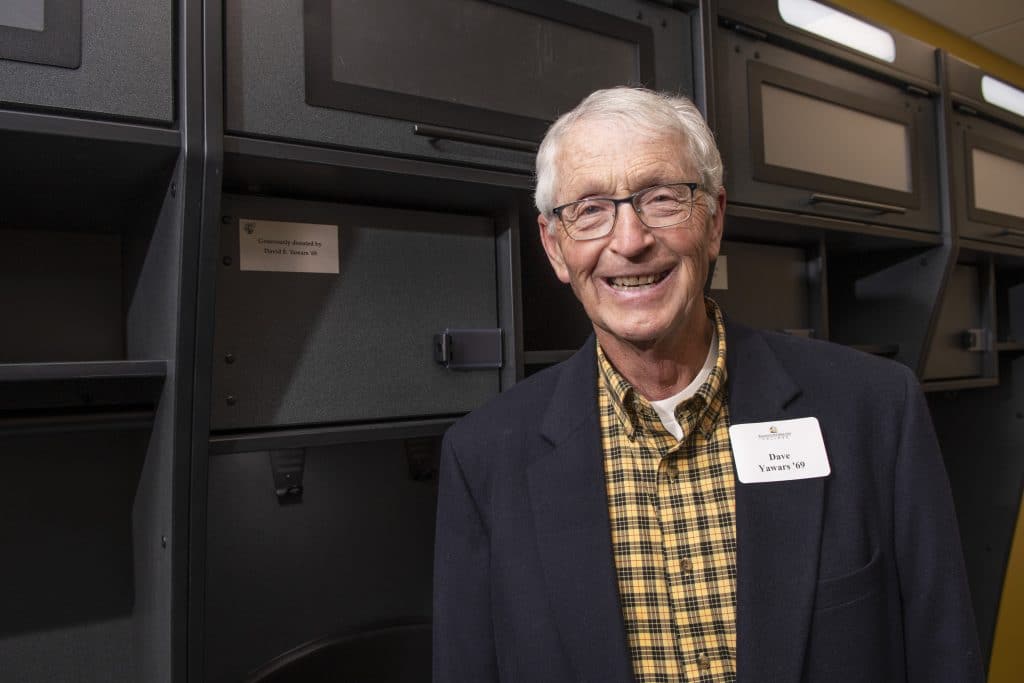 Donor Dave Yawars in front of locker he sponsored