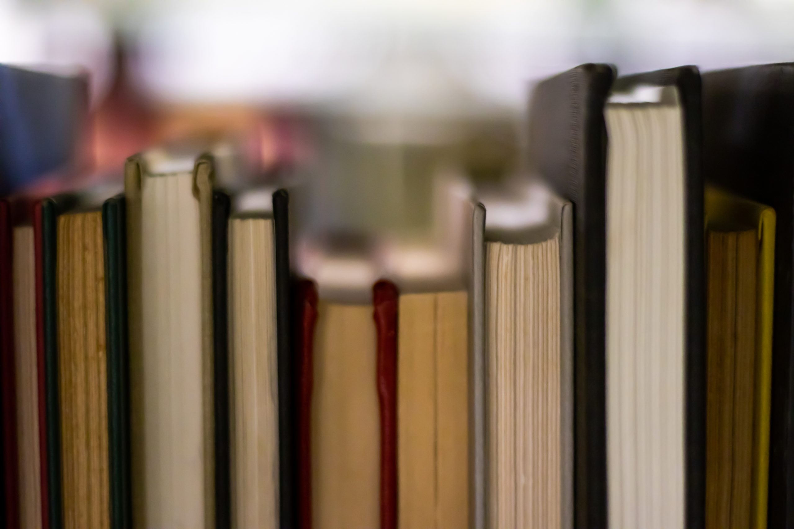 A close-up of various hardcover books, their pages and spines in soft focus.