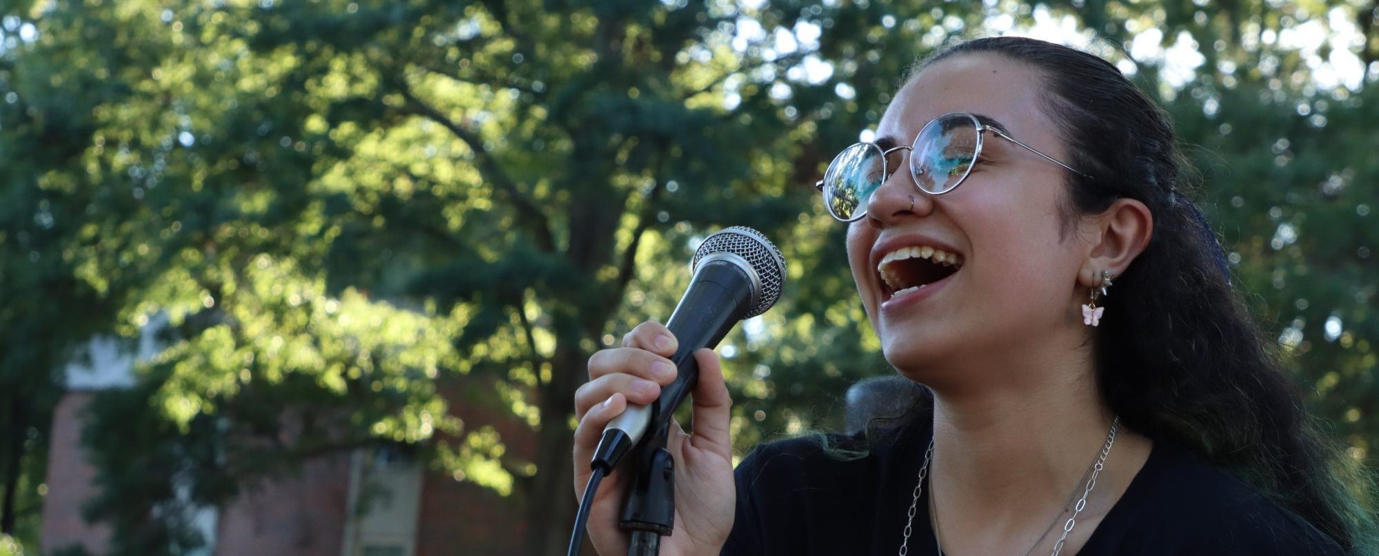 RMC student singing into a microphone during campus celebration.