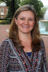 Rosemary Nicholson smiles outdoors in front of a fountain and brick walkway.