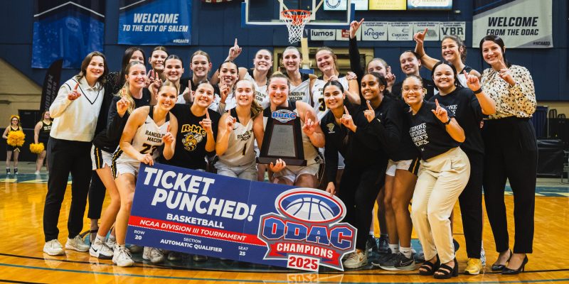 The 2024-25 RMC Women's Basketball team poses on court with the ODAC trophy and a sign that says "ticket punched!"