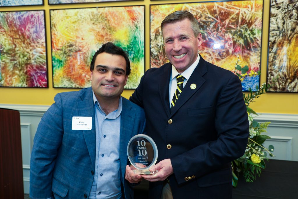 Kirby Struhar stands with RMC President Michael Hill, holding a 10 Under 10 award