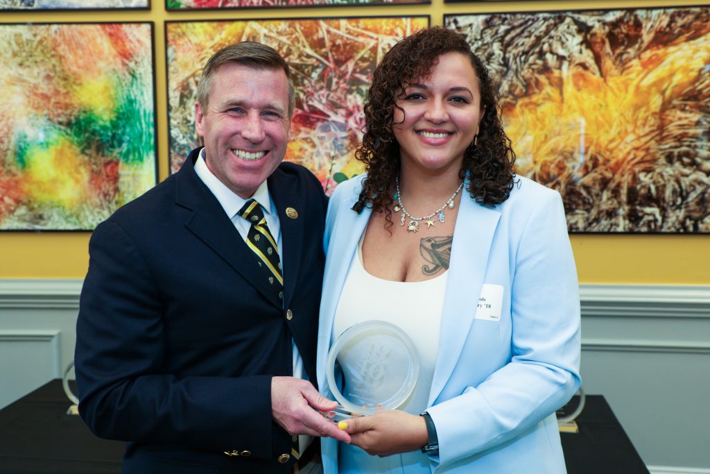Neecole Gregory stands with RMC President Michael Hill, holding a 10 Under 10 award