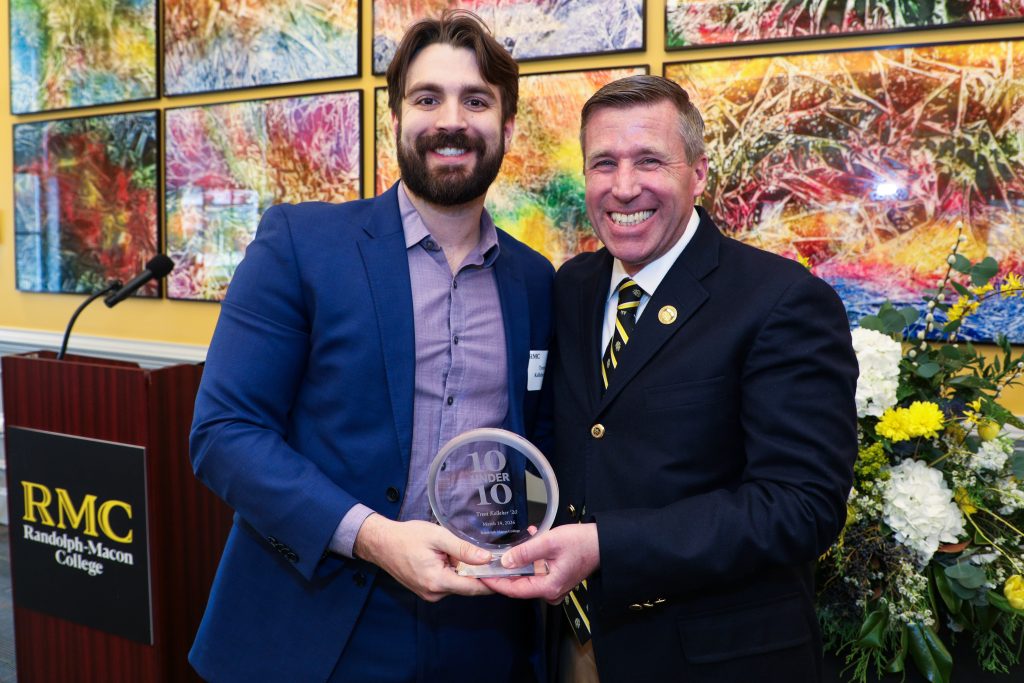 Trent Kelleher stands with RMC President Michael Hill, holding a 10 Under 10 award