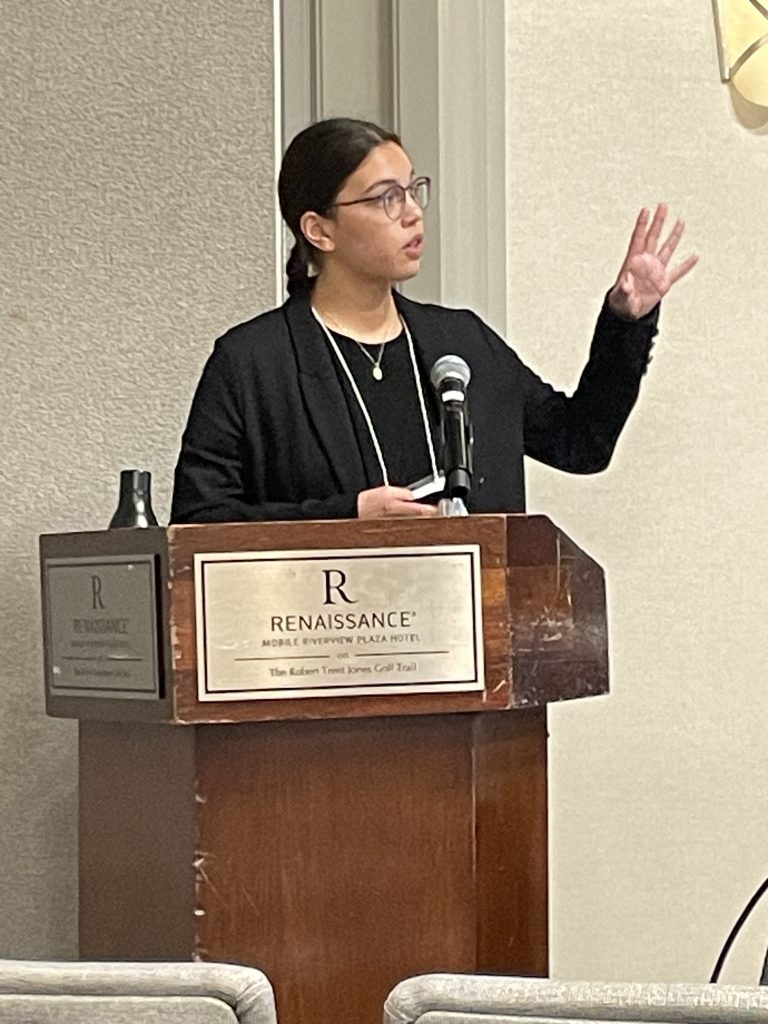 An RMC student gives a presentation at a lectern