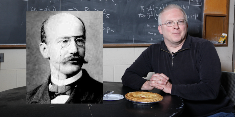Math Professor Adrian Rice sits at a table with a cherry pie, a blackboard with math equations in the background, and an image of mathematician Ferdinand Lindemann to his left.