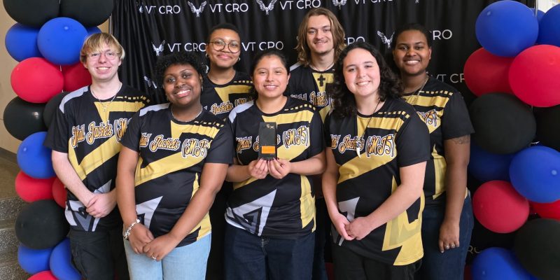 The RMC Robotics team poses with the Judge's Award trophy in front of a backdrop at the Virginia Tech CRO Down