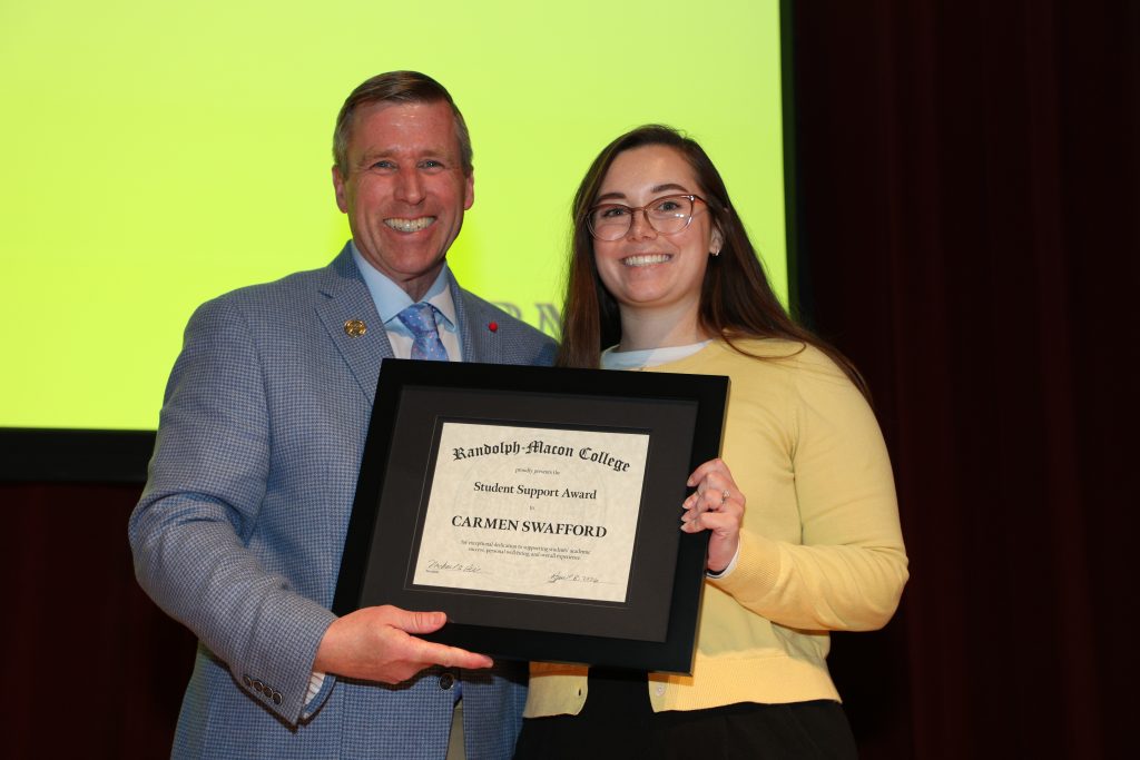 Carmen Swafford and President Michael Hill stand on the Blackwell stage holding a certificate