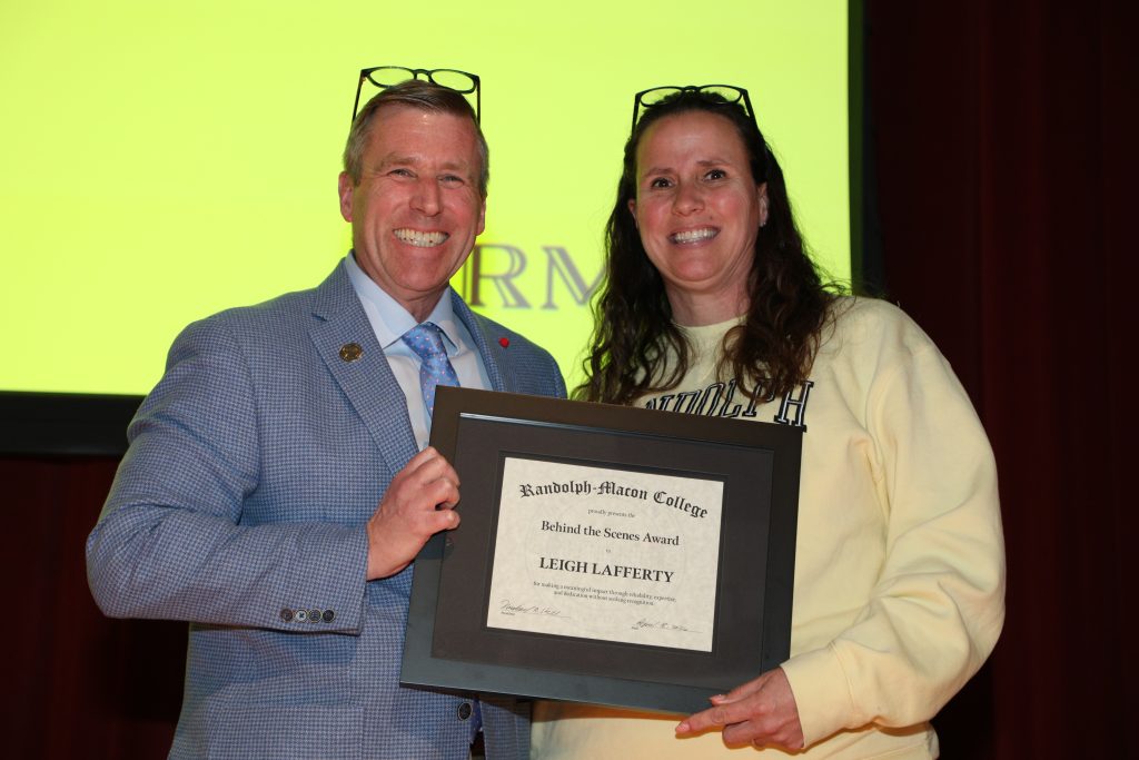 Leigh Lafferty and President Michael Hill stand on the Blackwell stage holding a certificate