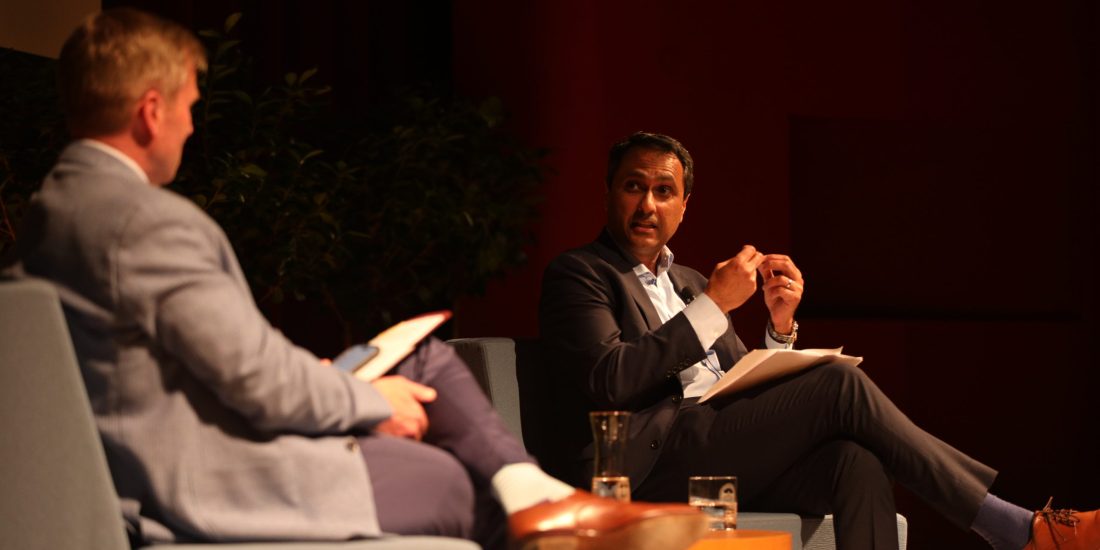 Eboo Patel and Michael Hill sit in chairs on the Blackwell Auditorium stage, having a discussion