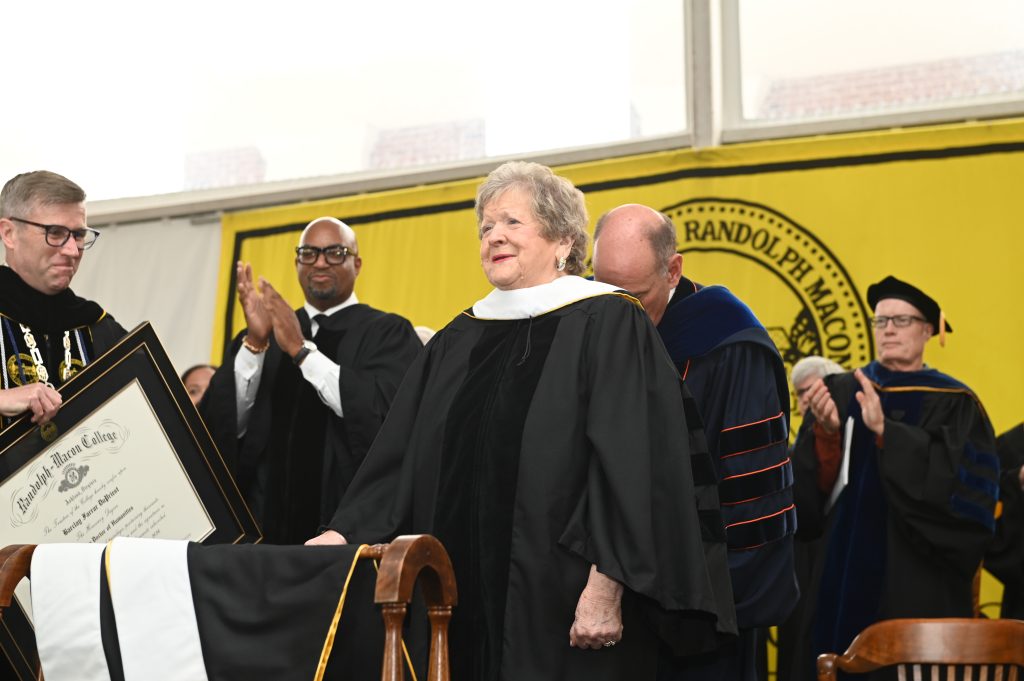 Barclay DuPriest stands on the Commencement stage to receive an honorary degree while receiving a standing ovation