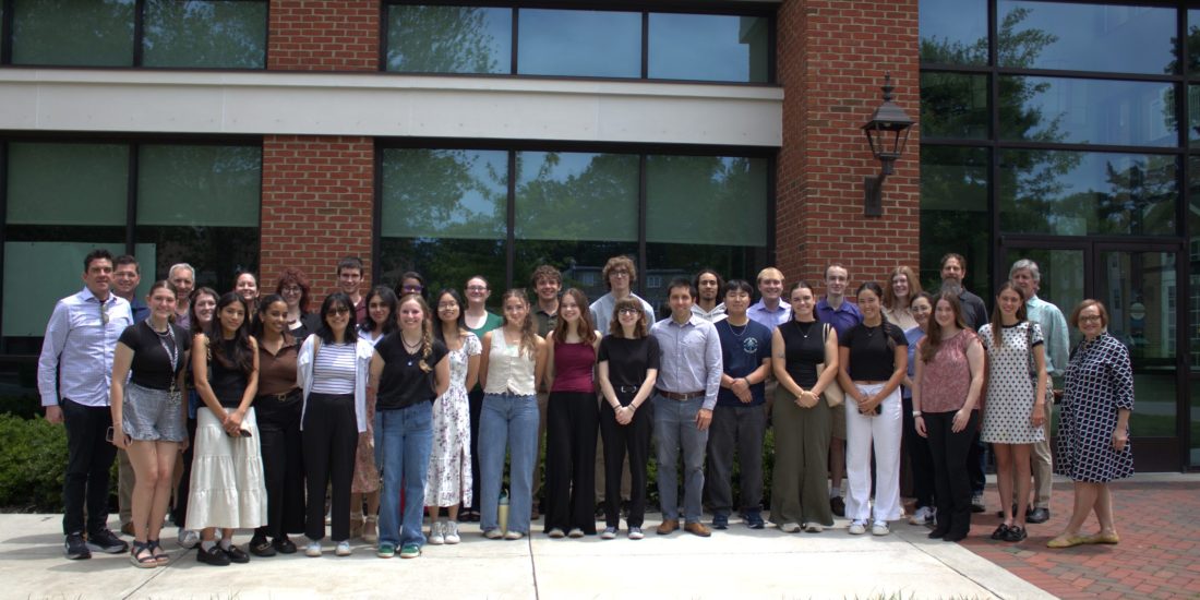 SURF students and their faculty mentors lined up in a group photo in front of Estes Dining Hall