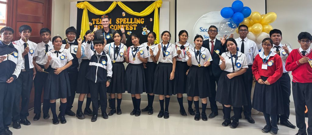 Peruvian students hold Randolph-Macon pencils and pose for a photo with an American teacher after a Spelling Bee