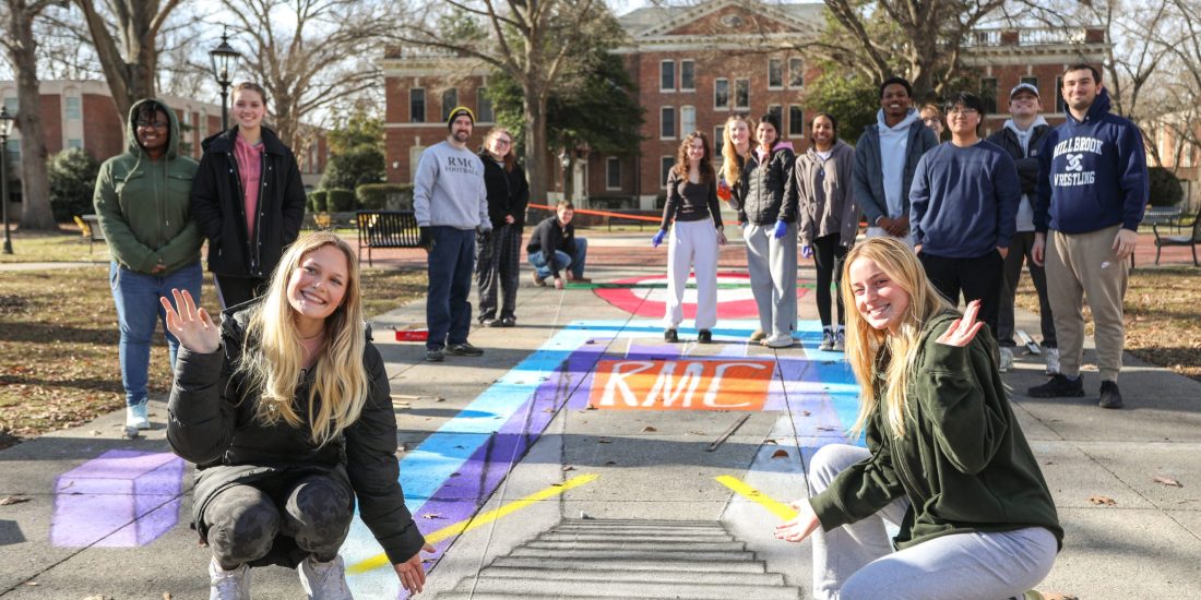 a group of students create optical illusions on campus sidewalks
