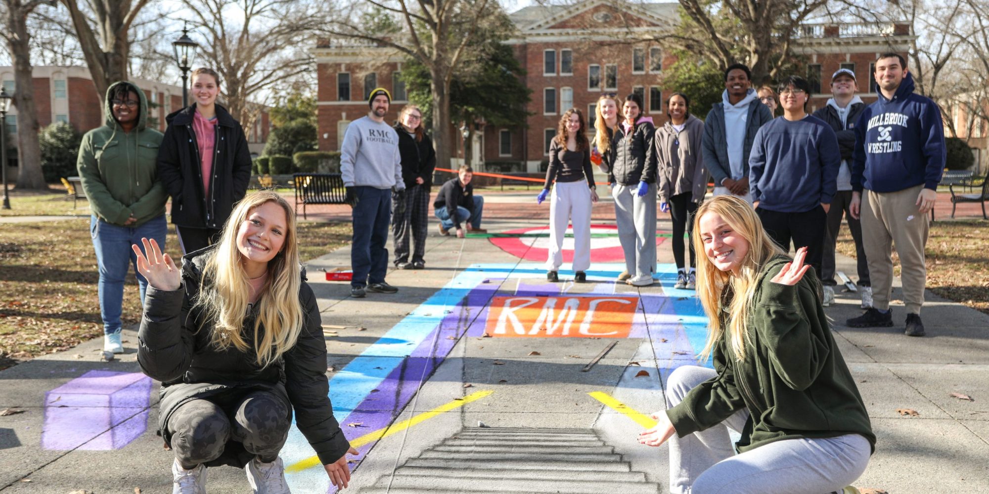 a group of students create optical illusions on campus sidewalks