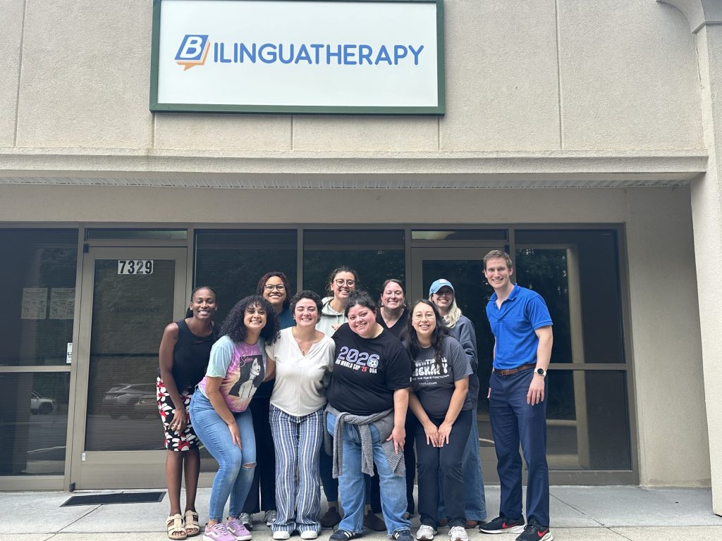 Valentina Ambrogi-Torres poses with her colleagues in front of the front entrance to Bilinguatherapy