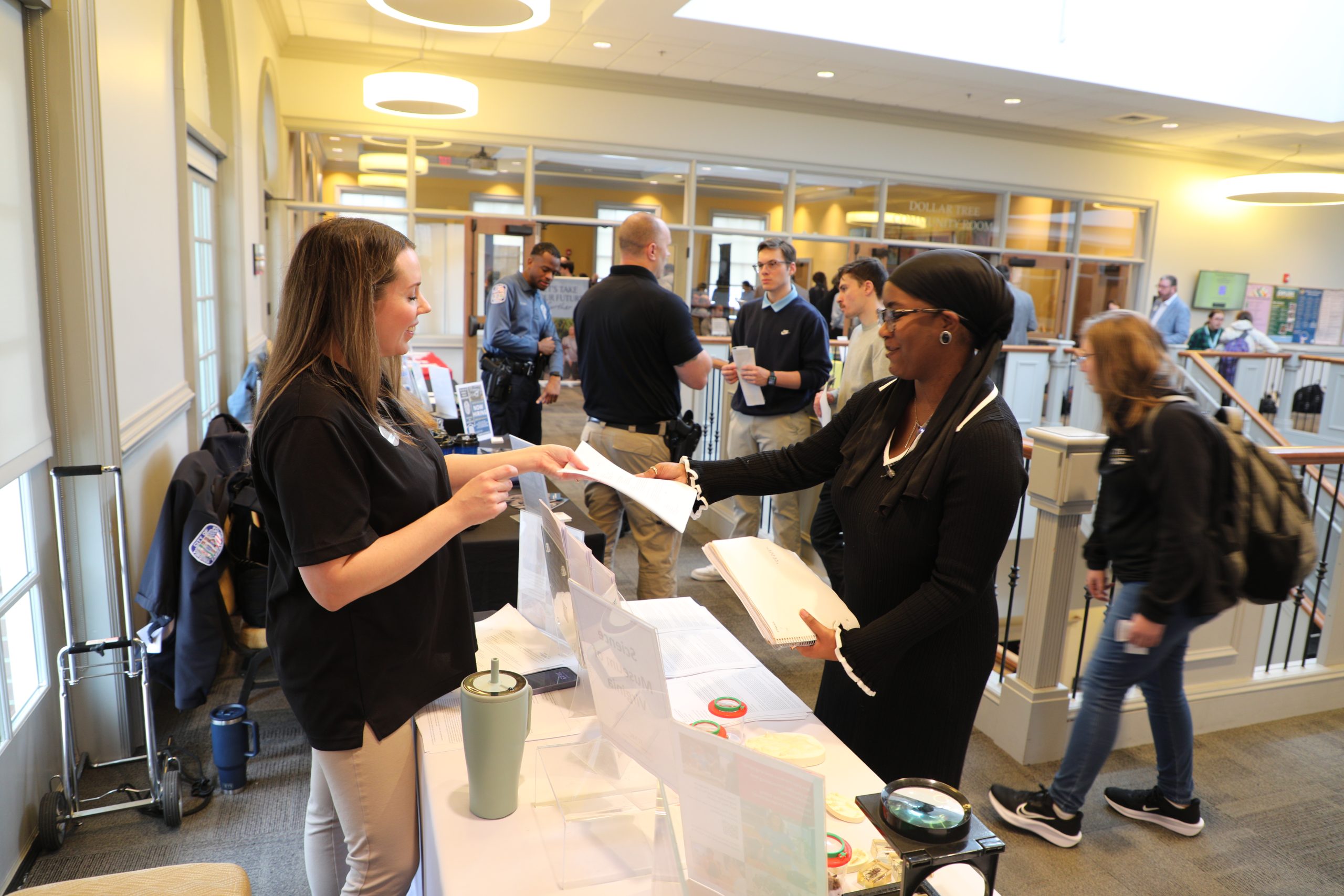 A student and employer interact during a career fair.