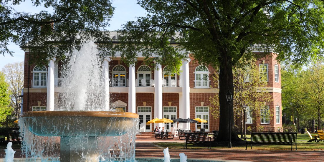 RMC's fountain stands in the foreground on a sunny day with Brock Commons in the background