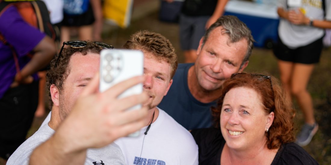 A student and family pose for a selfie.