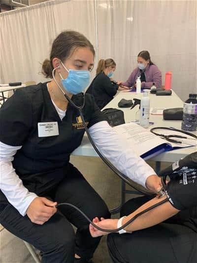 An R-MC nursing student checks a patient's blood pressure while volunteering at a free clinic in TN.