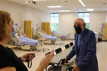 HAP Payne stands in the new Payne Hall surrounded by hospital beds to be used in nursing education.